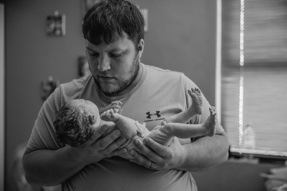 Dad looking at baby home birth photographer cape town By Grace Photography