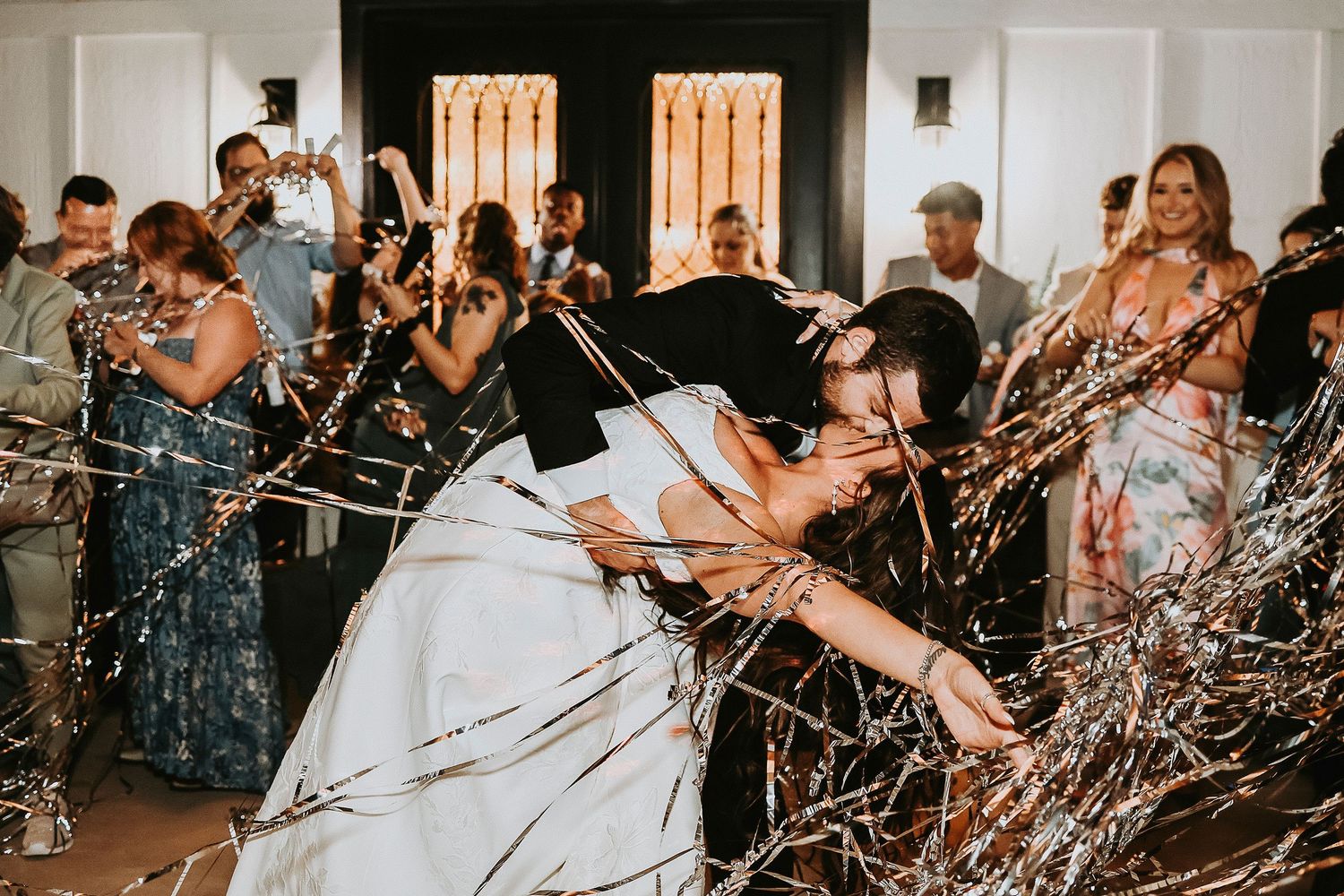 bride and groom exit their wedding reception surrounded by their friends and family at the madelyn wedding venue