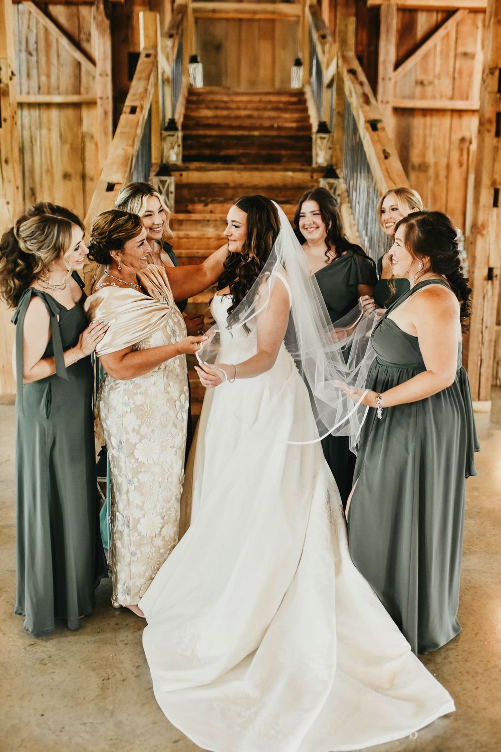 Elegant bridal party posing in green dresses with white bouquets