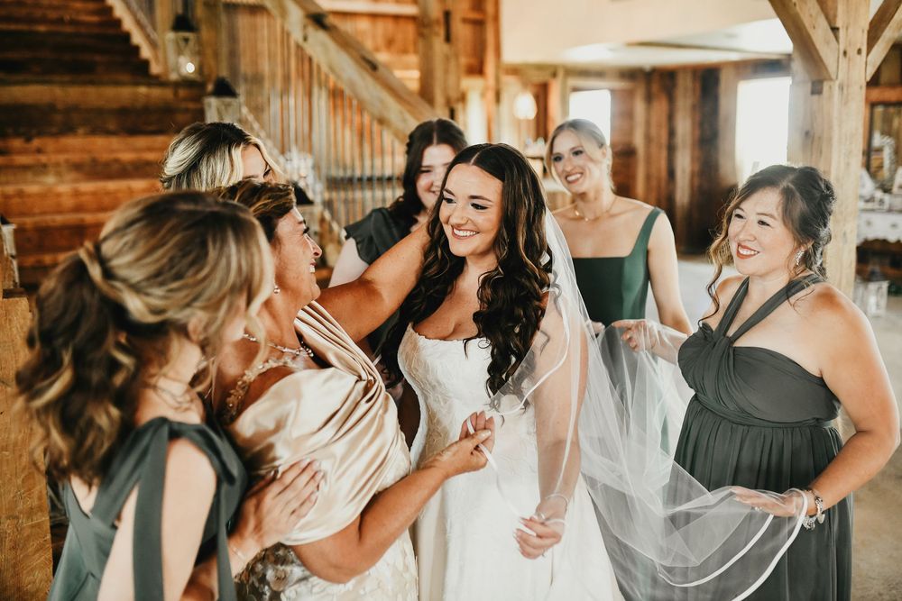 Bride with bridesmaids in satin green gowns at The Madelyn