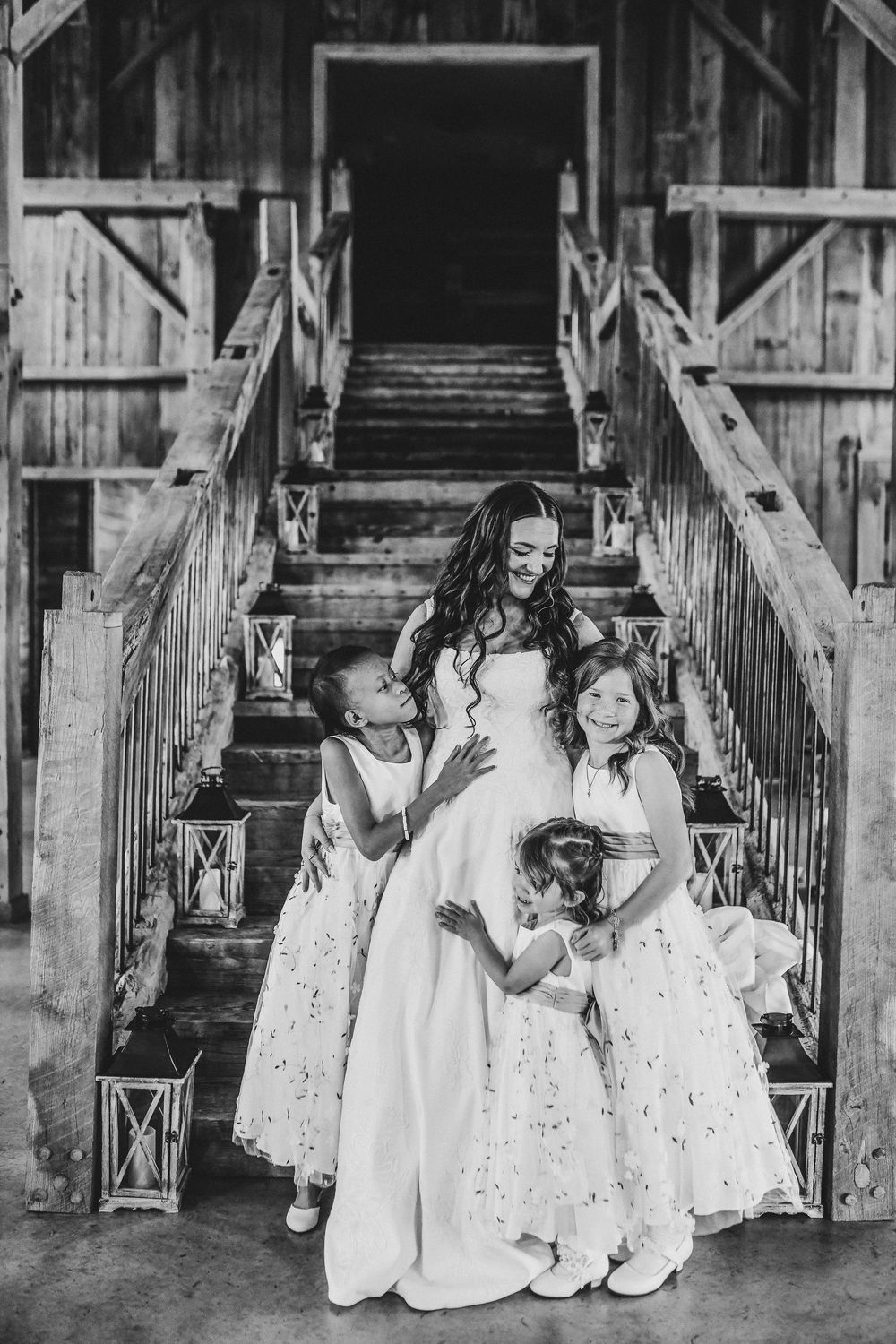 the bride hugs her flower girls just before her wedding