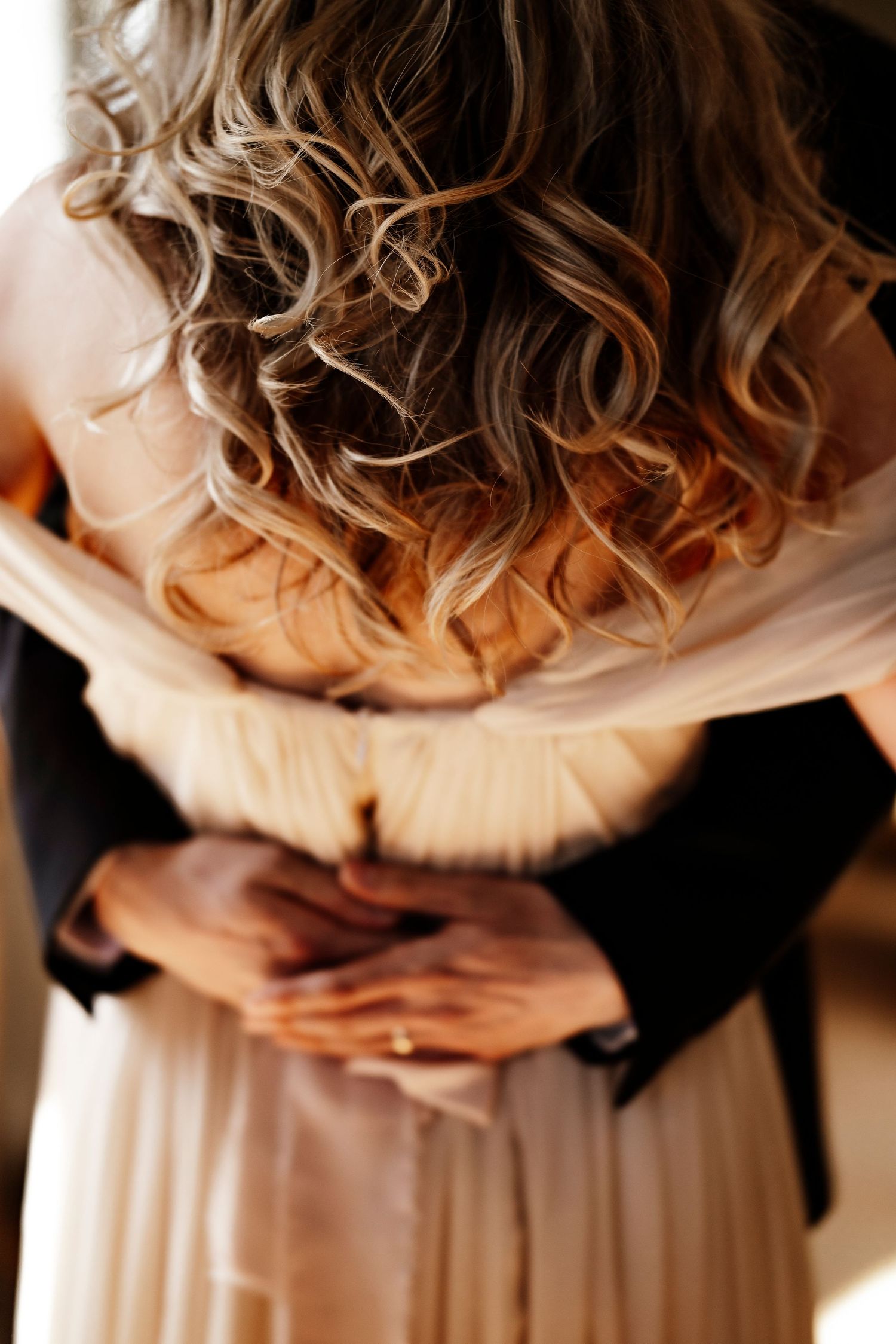 Romantic couple dancing in a vintage room with wooden floors and large windows as sunlight streams in.