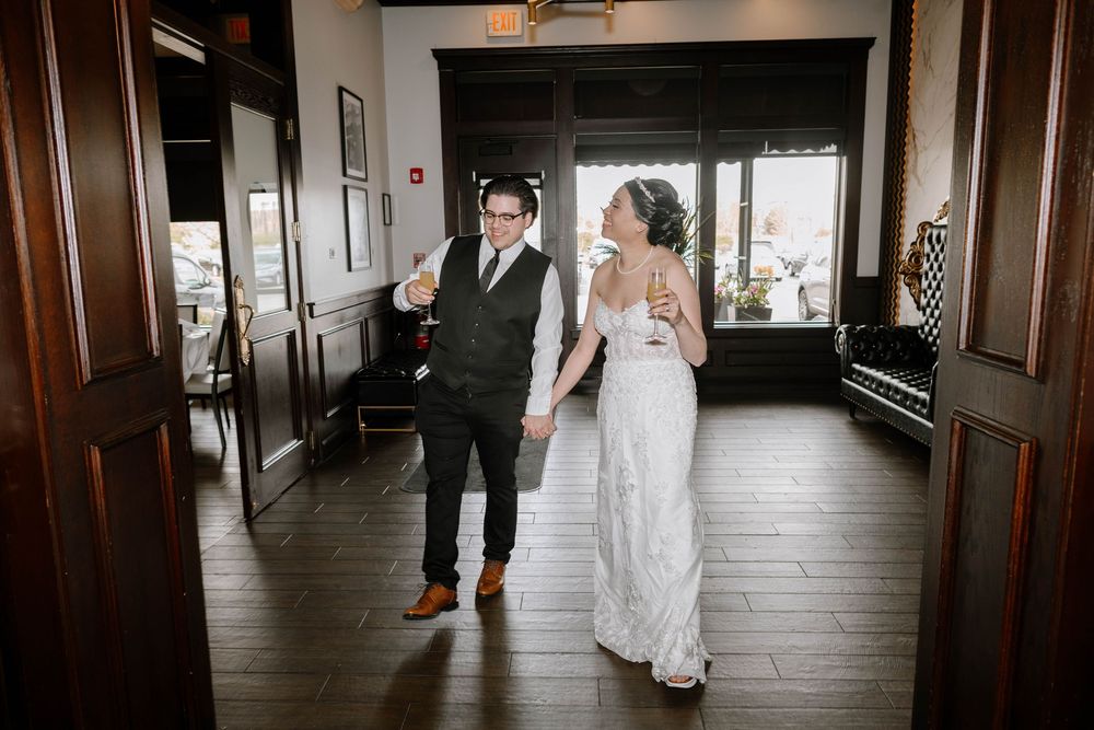 A couple shares a first look moment in a dark wood-paneled hallway during their wedding celebration.