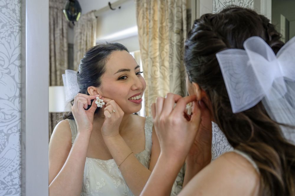 Bride fixing her earrings before her wedding at Cragwood Country House