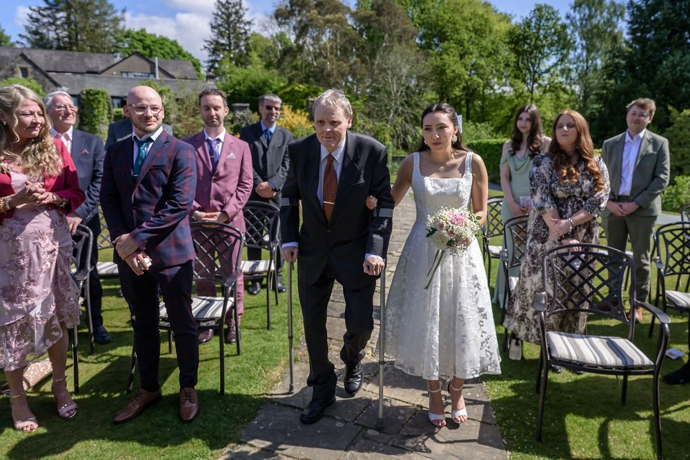Bride walks down aisle with her father at outdoor wedding at Cragwood Hotel near Ambleside