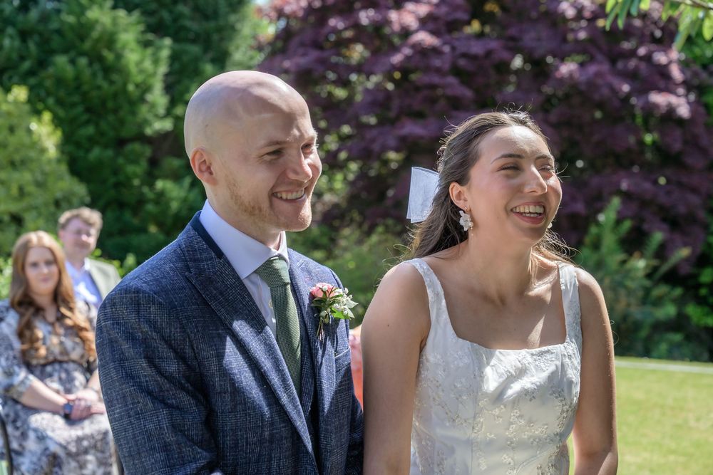 Bride and groom laughing during their outdoor wedding ceremony at Cragwood Country House