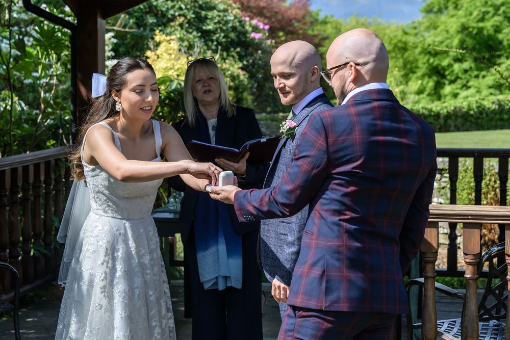Best man offering ring to bride during wedding ceremony at Cragwood Hotel