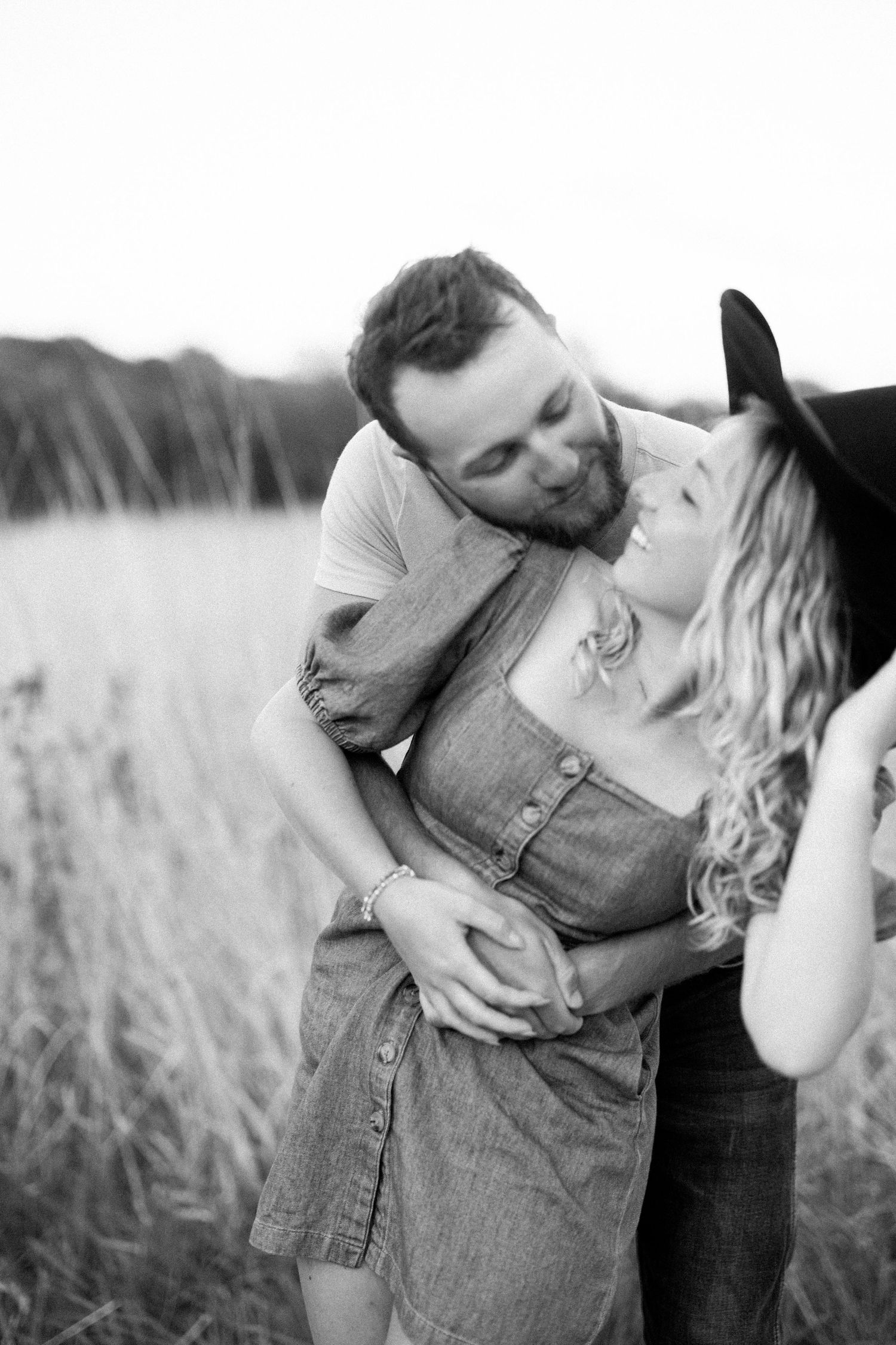 A romantic black and white photo sequence shows a couple embracing and kissing in a field of tall grass.