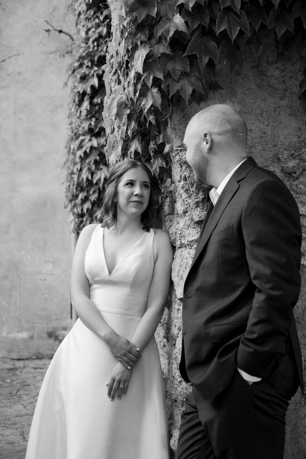 Romantic black and white portrait against an ivy-covered wall at a wedding venue.