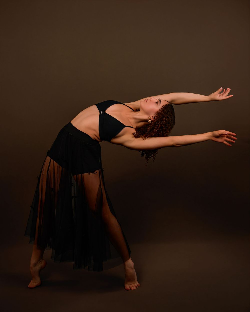 dancer Evelyn posing in a Tucson photography studio with dramatic lighting