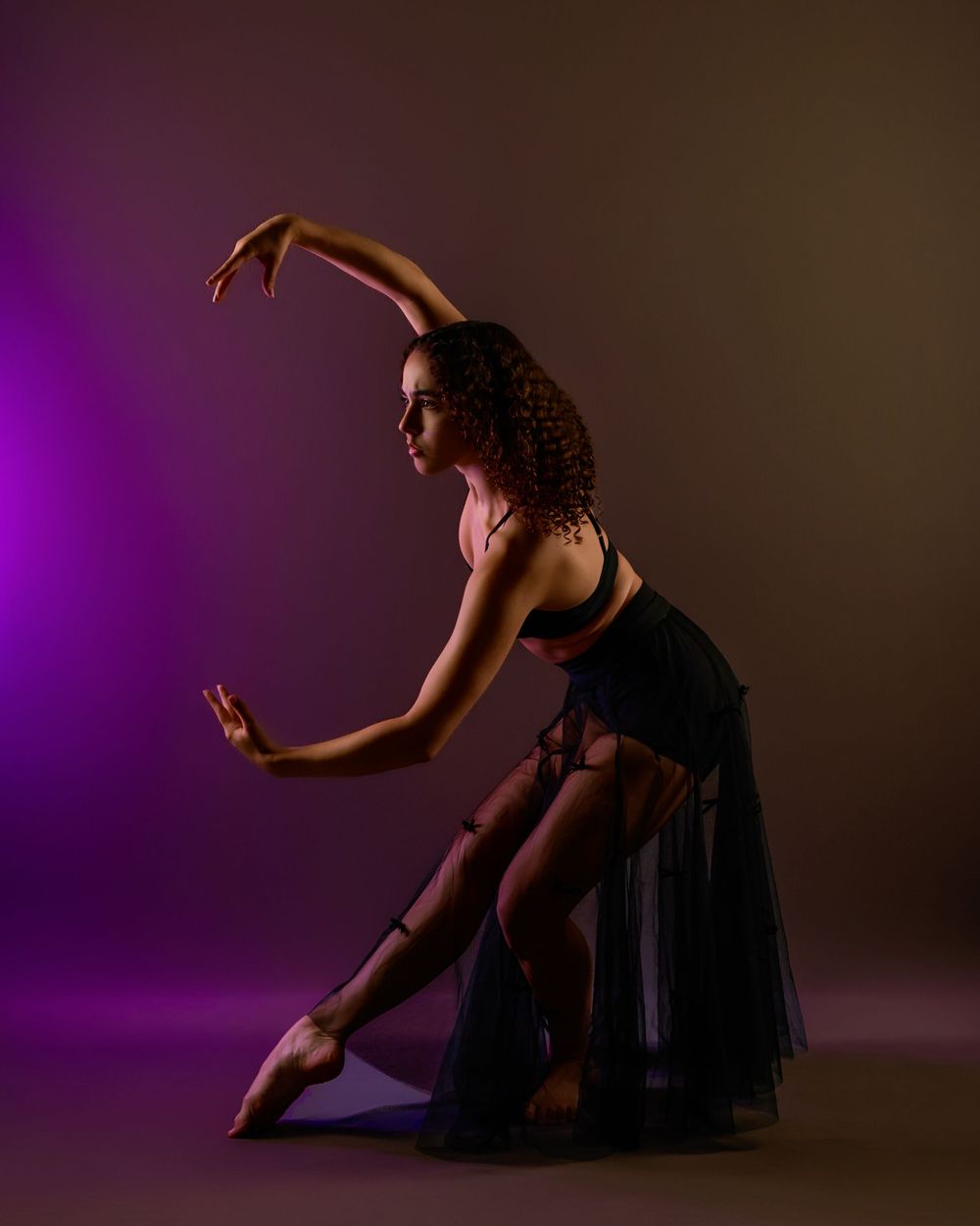 dancer Evelyn posing in a Tucson photography studio with dramatic lighting