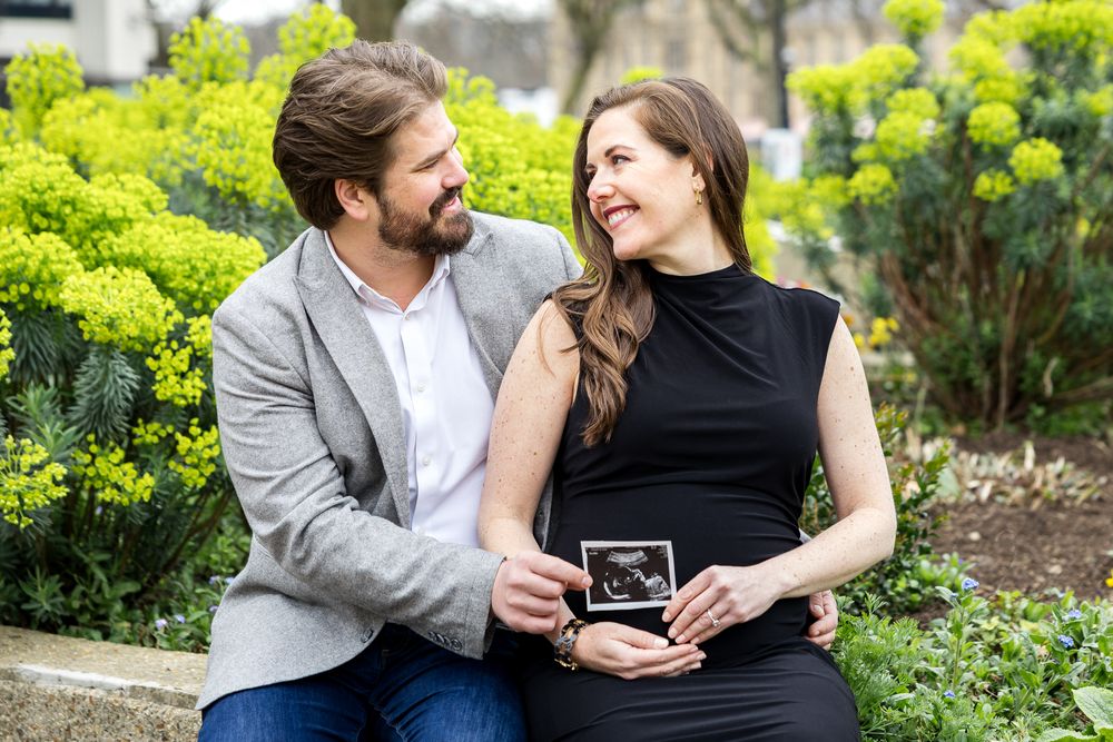 husband and wife holding ultrasonography photo of their baby