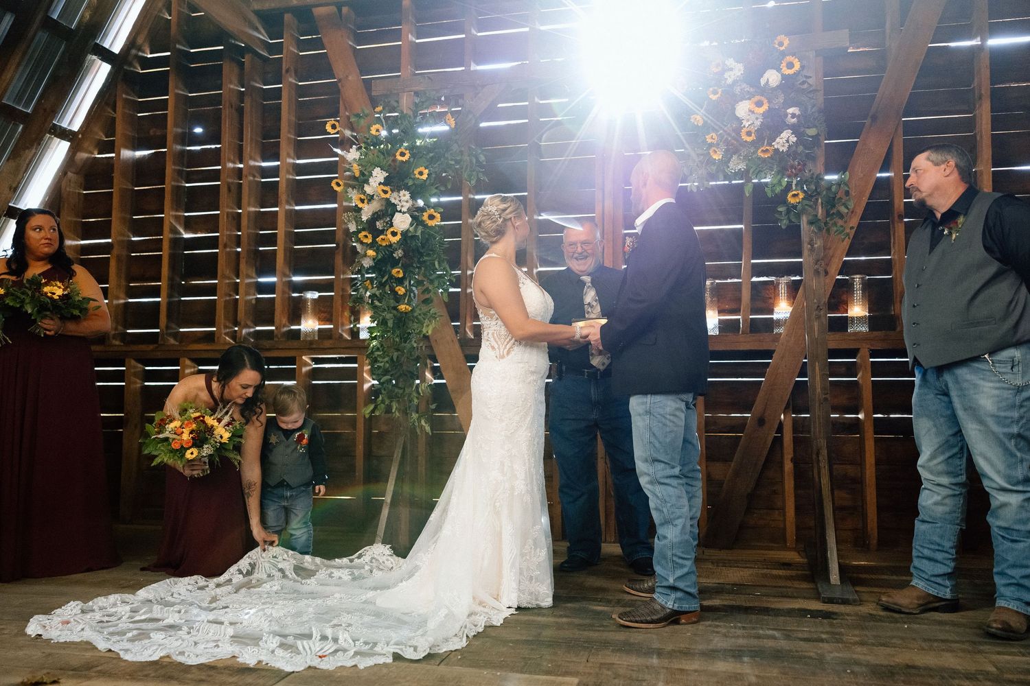 Two individuals share a joyous dance together in a rustic barn-style venue with wooden lattice walls and warm lighting.