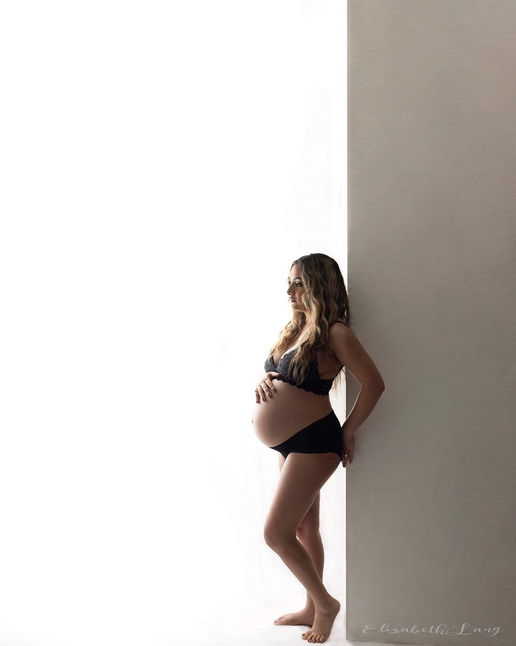 bra and under wear mom leans against a wall. Maternity photos Surrey Vancouver Elizabeth Lang Photography