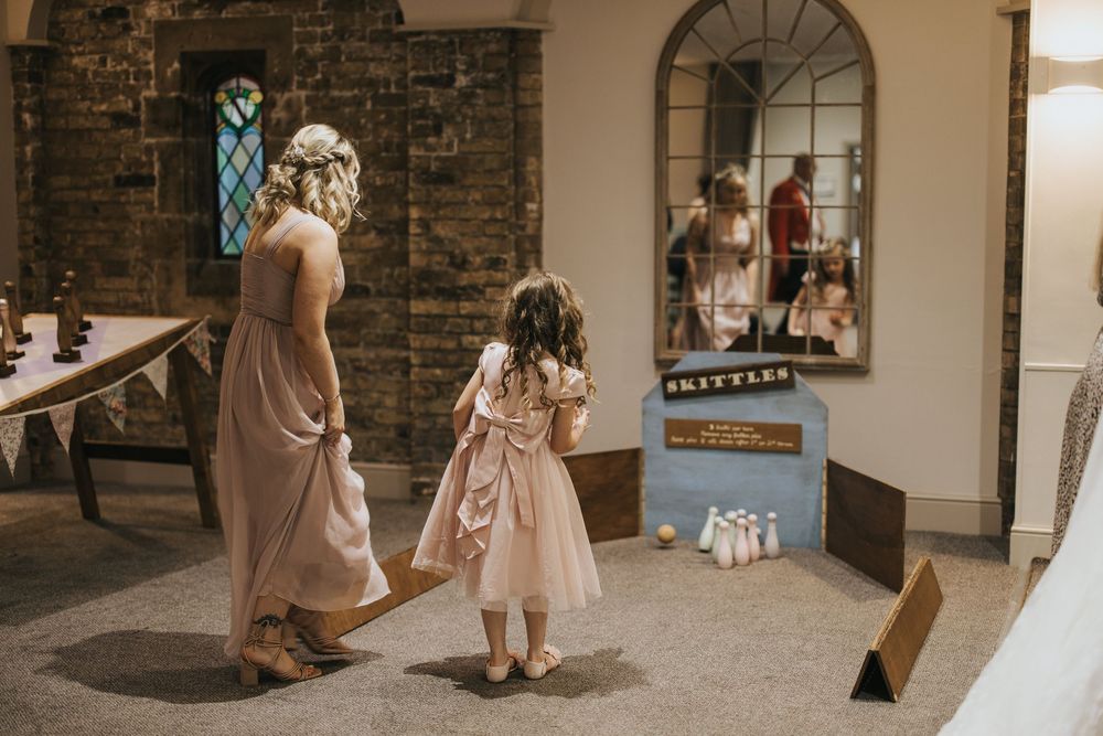 Two figures in wedding attire play games inside Cave Castle - taken by Grimsby photographer.