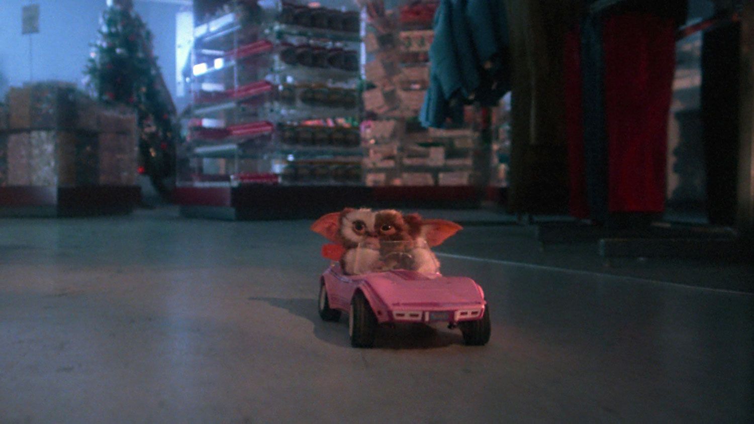 Scene from Gremlins with Gizmo driving his pink Corvette