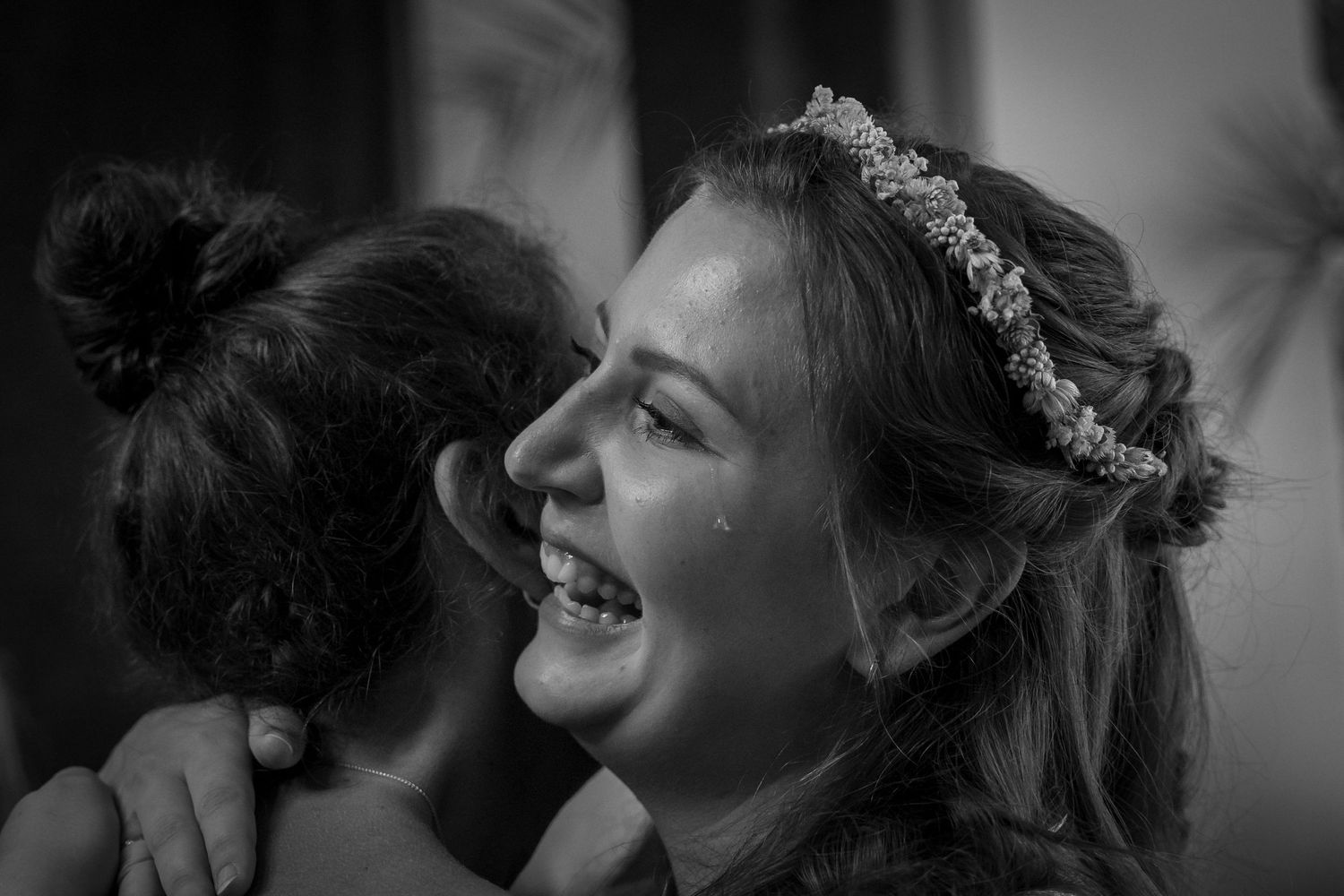 Hochzeitsfotograf Berlin – Braut lächelt bei Umarmung mit Gast Schwarz-Weiß