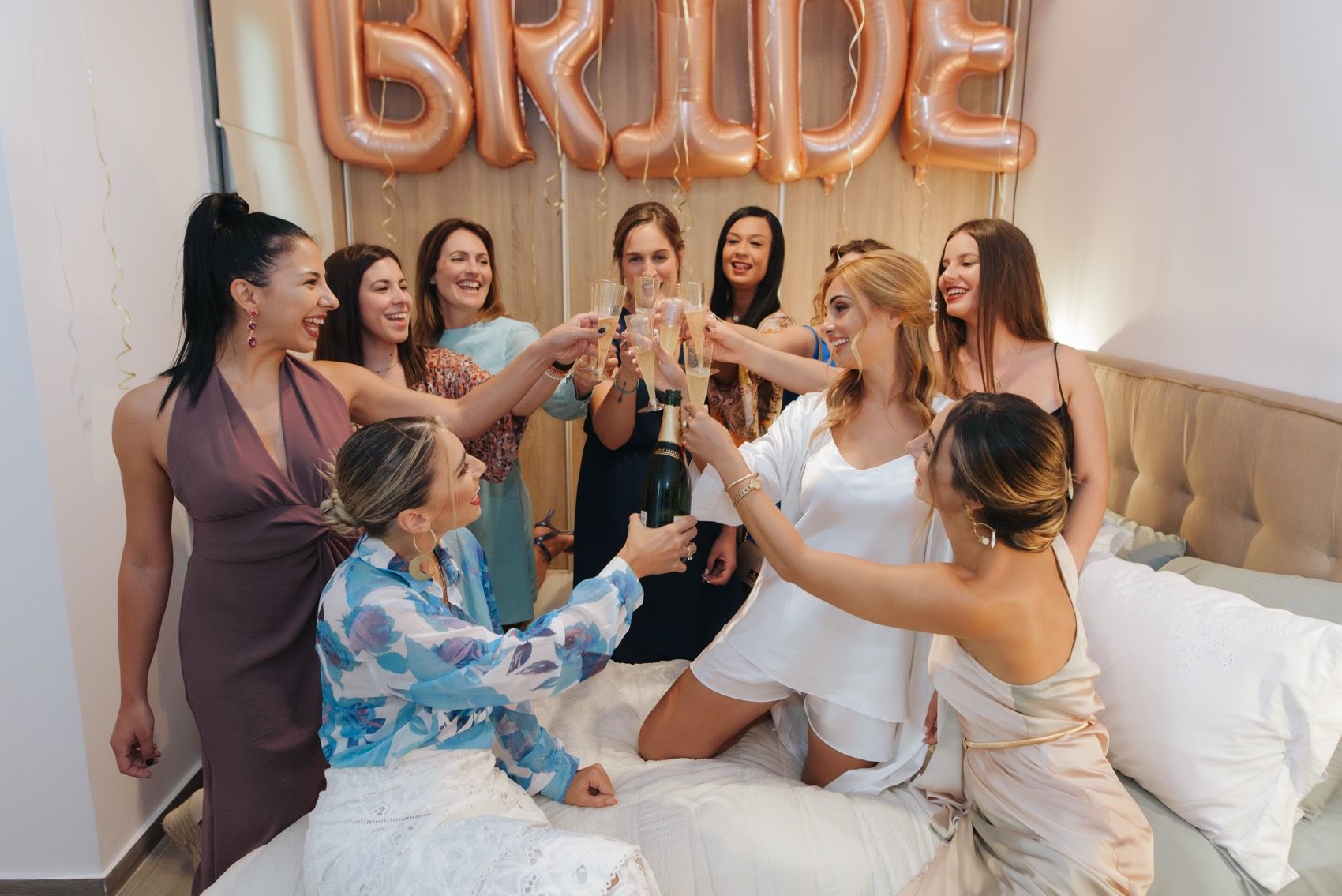 Joyous wedding party candid moments captured in five progression photos showing celebration in a bridal suite.