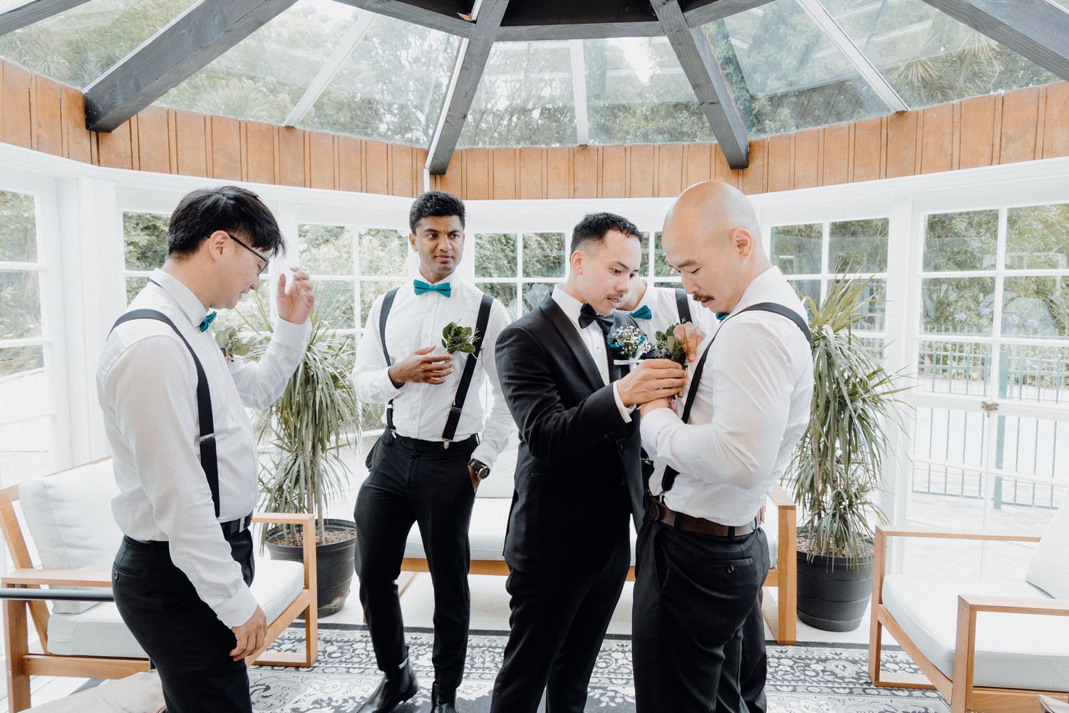 A group in formal attire with suspenders and dress shirts captured by Apertured Media Auckland Wedding Photographer.