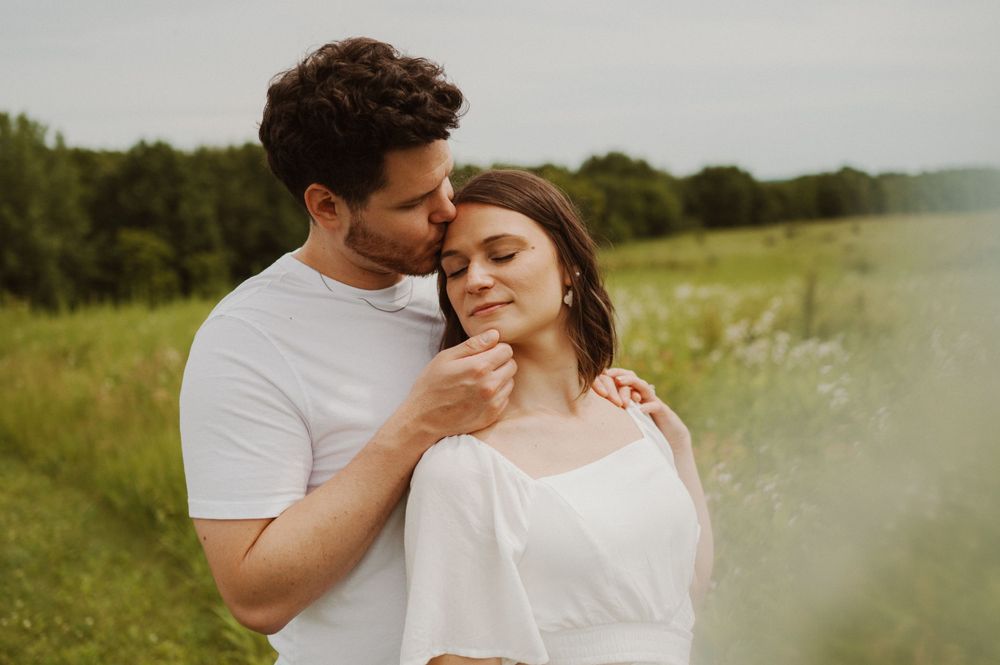 A tender intimate moment between a couple in a sunlit field.