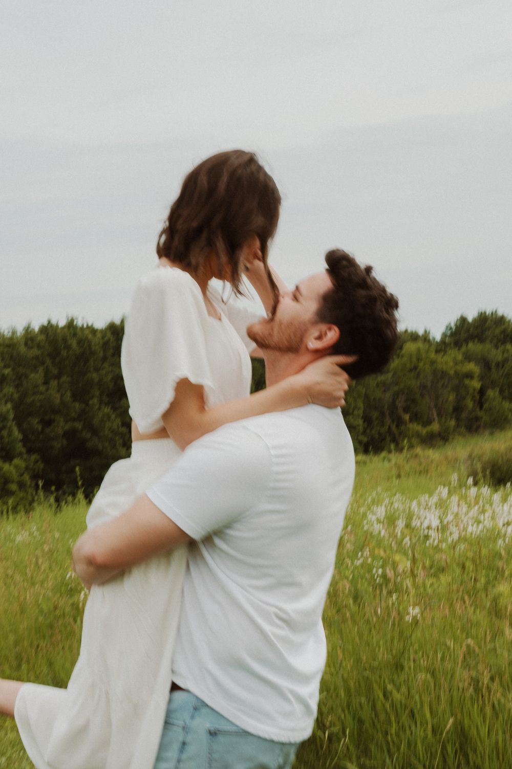 Dancing couple sharing an intimate moment in a sunlit meadow.