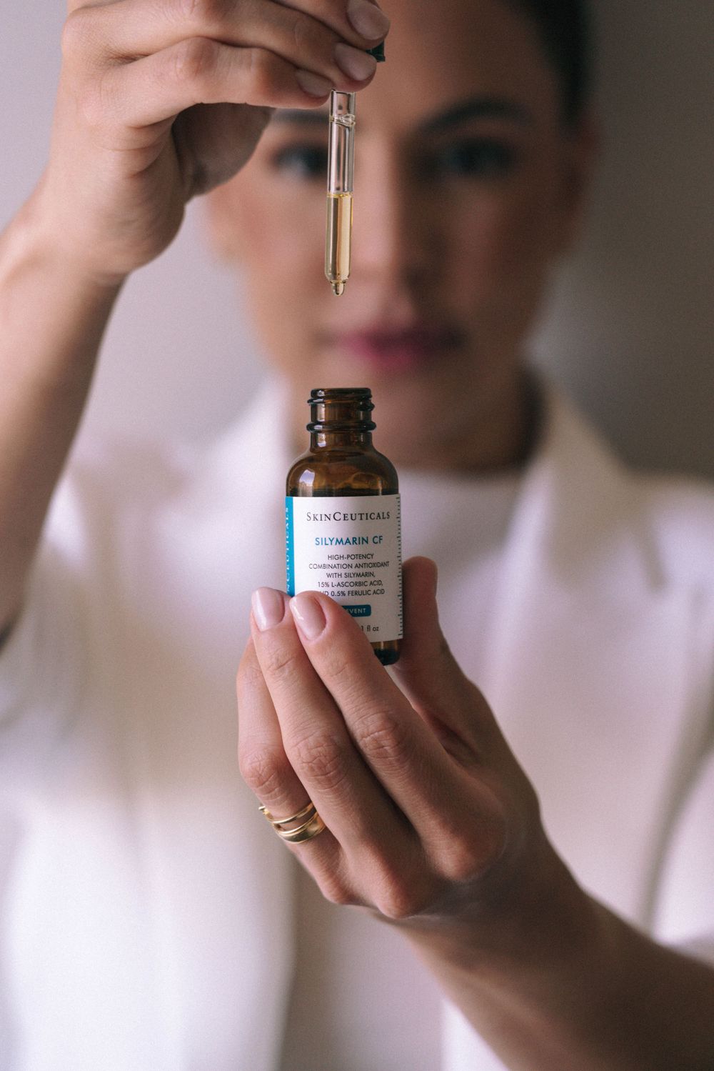 Branding Photography Sessions capture hands holding a dropper and essential oil bottle against a blurred background, showcasing storytelling