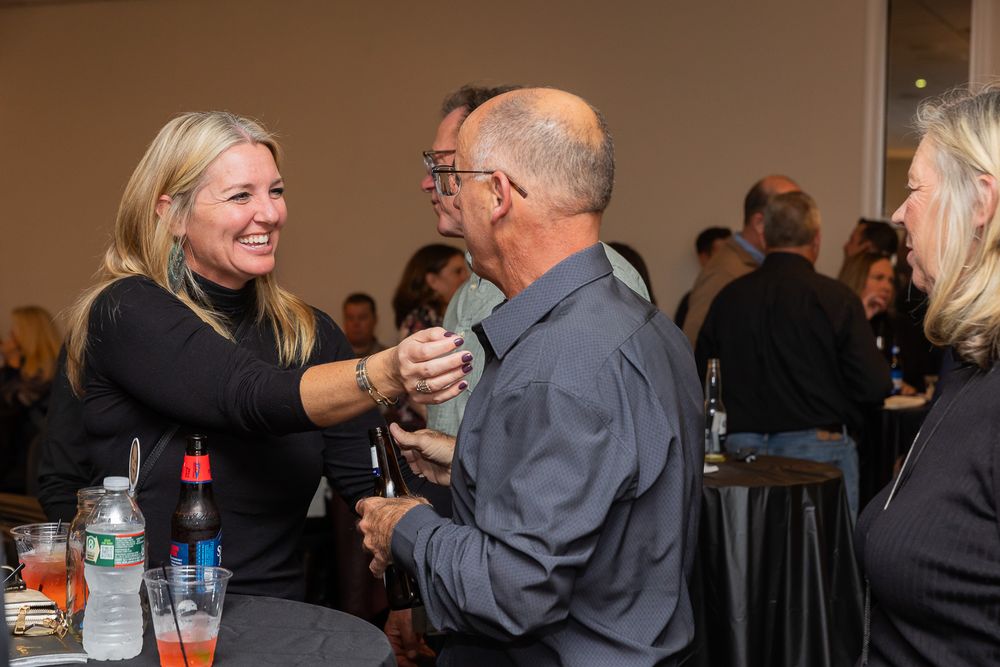 Guests engaged in animated conversation during a festive indoor gathering.