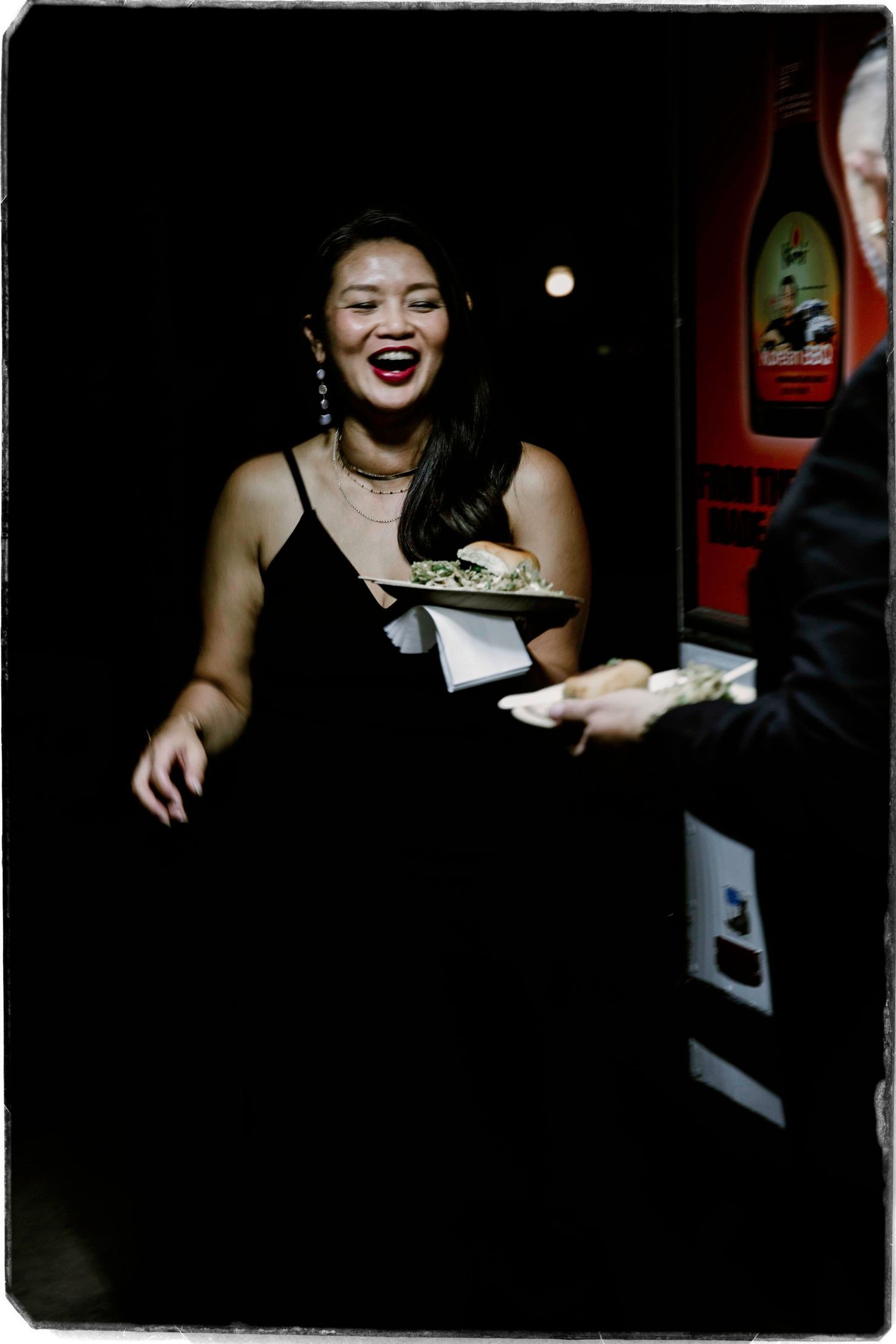 A joyful moment captured in a dark restaurant setting as money is exchanged during service.