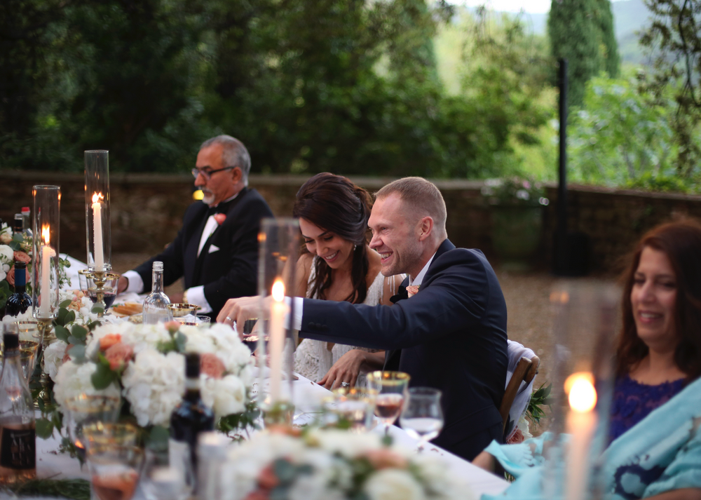 Ett vackert spontant brudporträtt vid middagsbordet, dukningen är vacker med blommor och ljus.
