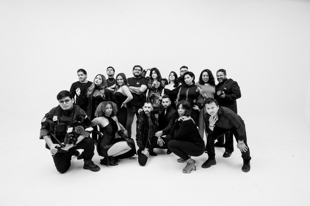 Large group of people posing together in black and white photo against white background.