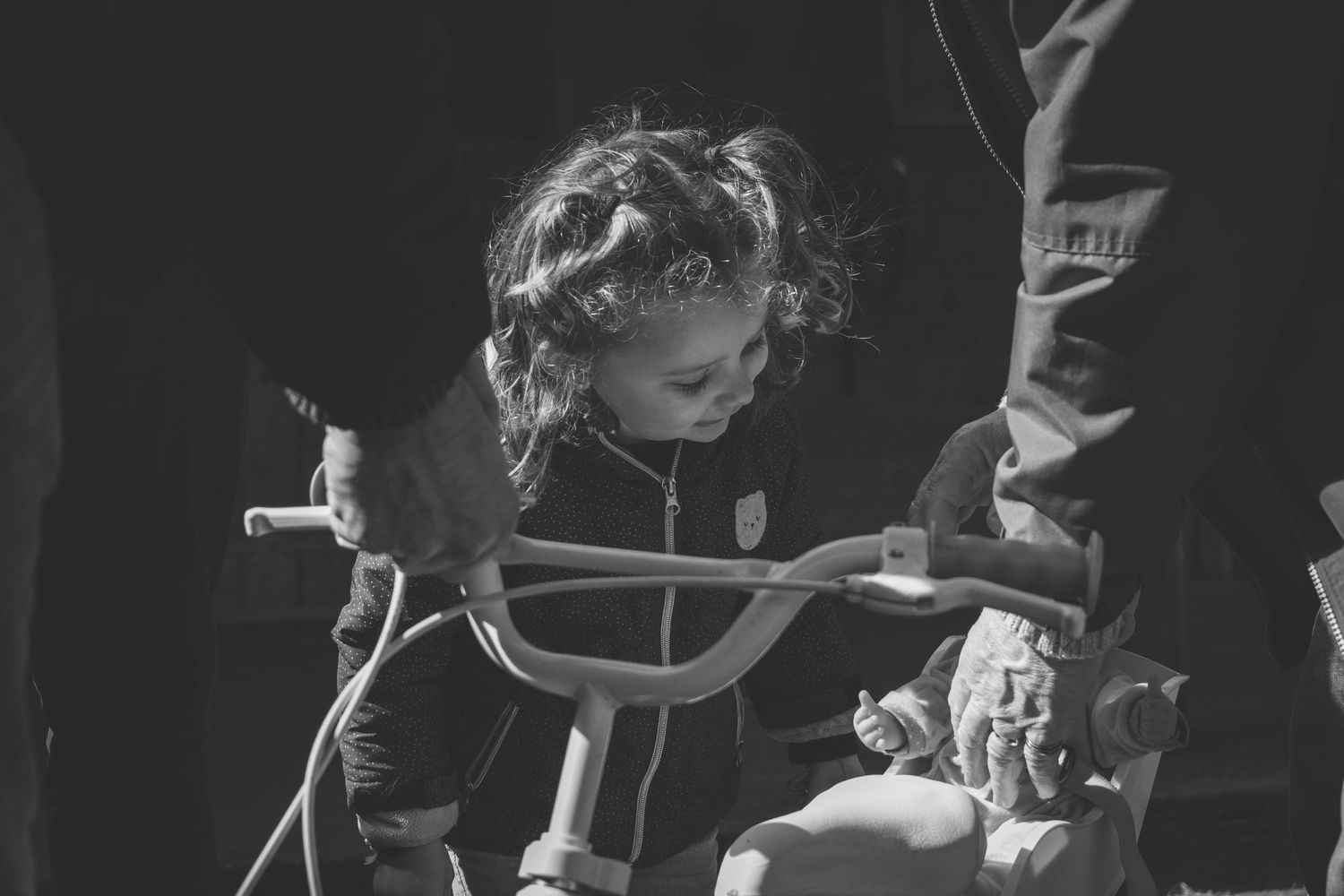 Photographie d'une enfant avec un vélo et sa poupée