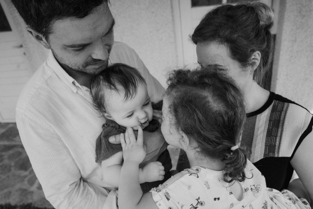 A family shares an intimate black and white moment together indoors.