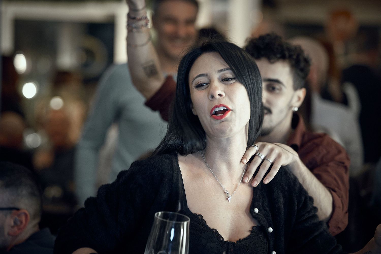 Party scene in a bar with people dancing and celebrating.