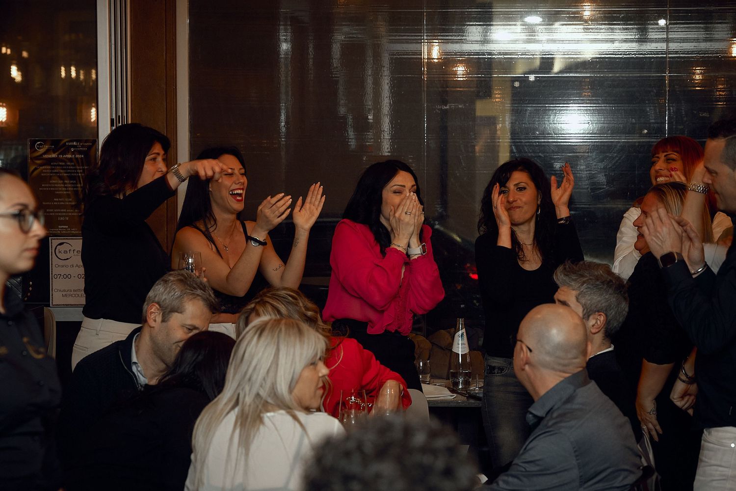 Group of people laughing and enjoying themselves at a nighttime gathering.