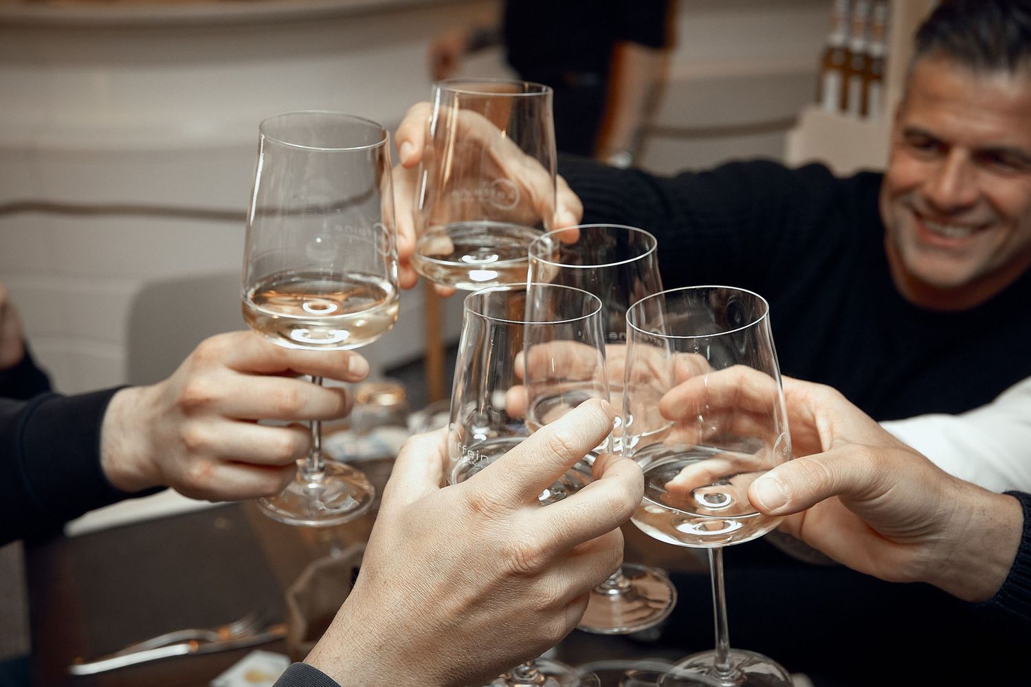 Hands toasting with wine glasses in celebratory moment.