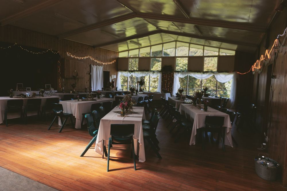 Wedding reception venue with white tablecloths and string lights decorating the ceiling.