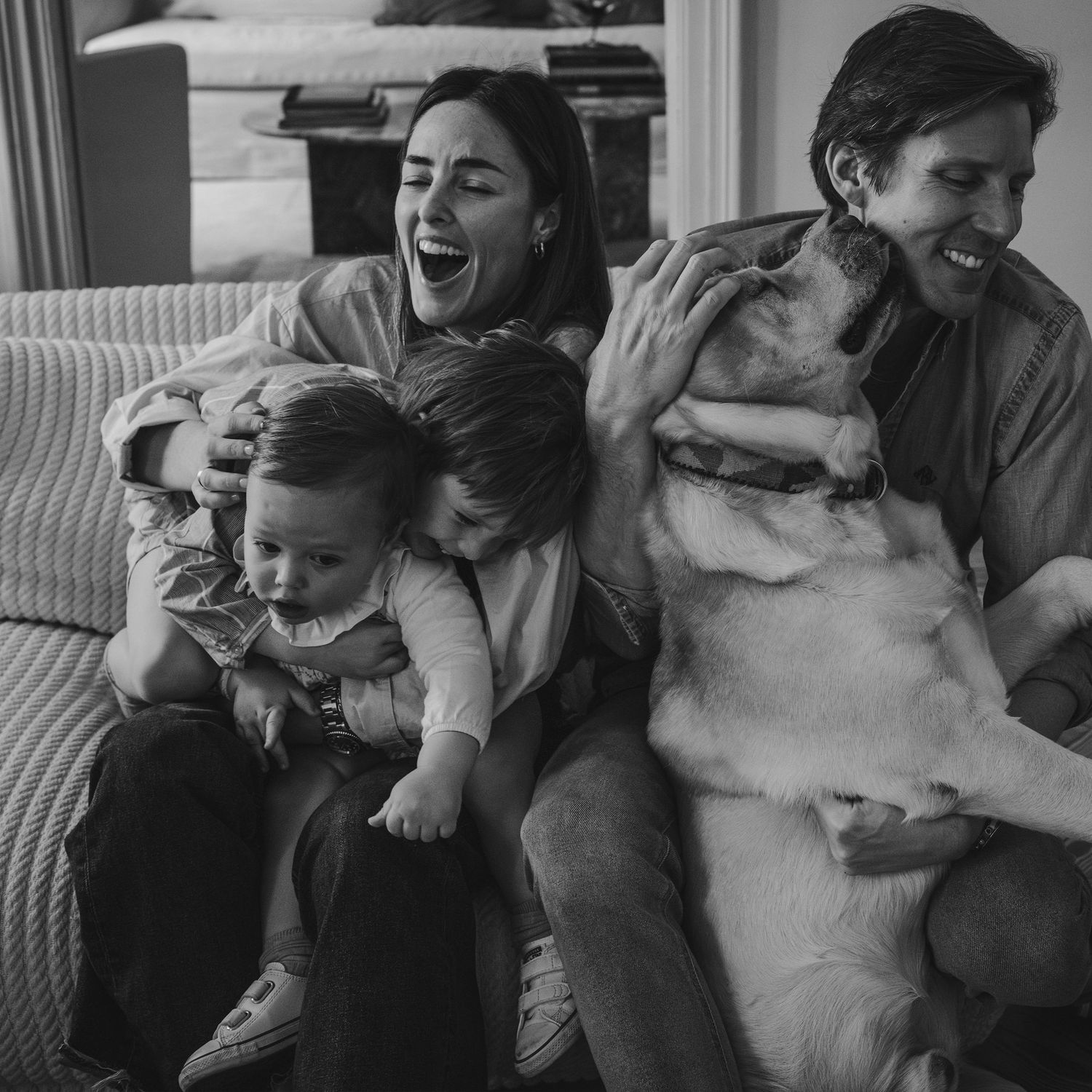 escena espontánea y natural de familia en su casa en un domingo cualquier. madre padre dos hijos pequeños y perro