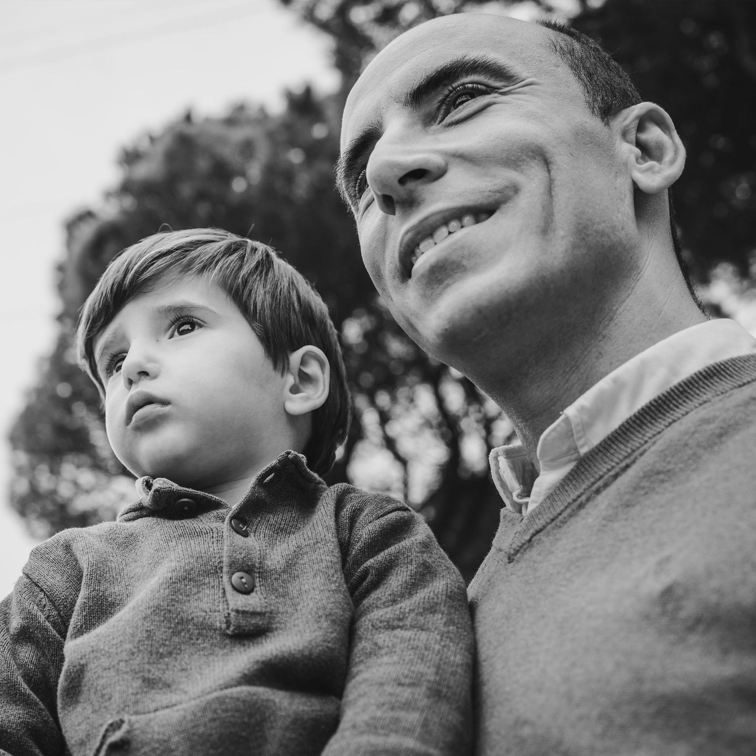 padre con hijo en los brazos mirando el paisaje parque Dehesa Las Rozas sesión fotográfica en exterior