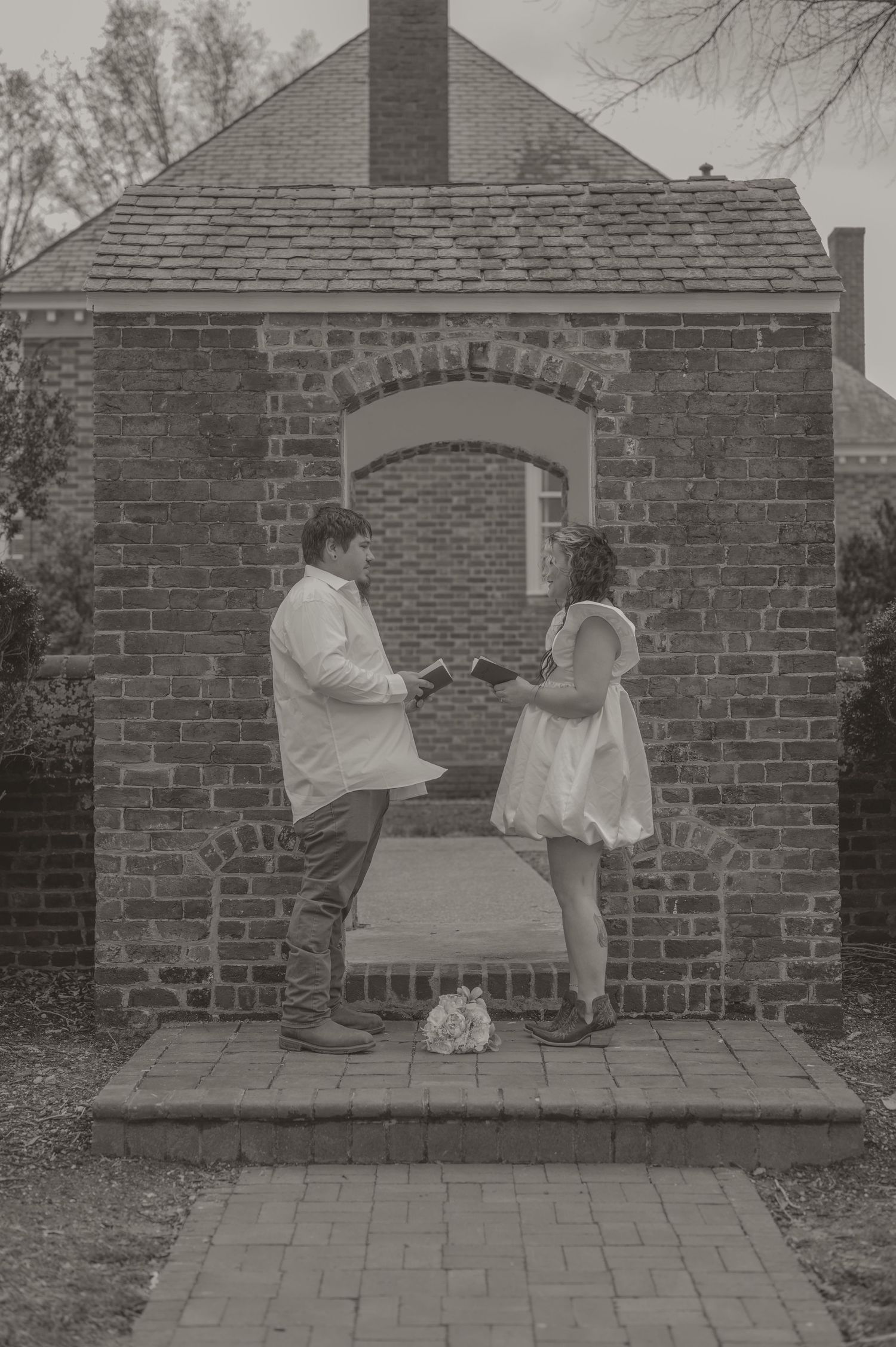 An elopement couple shares a romantic moment on a brick porch of a historic building. photo by Samantha Campbell imagery