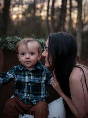 Intimate mother and child portrait in rustic outdoor setting at dusk.