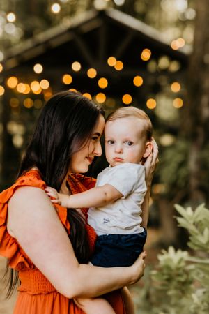 A sweet moment between parent and toddler with warm bokeh lights glowing in the background.