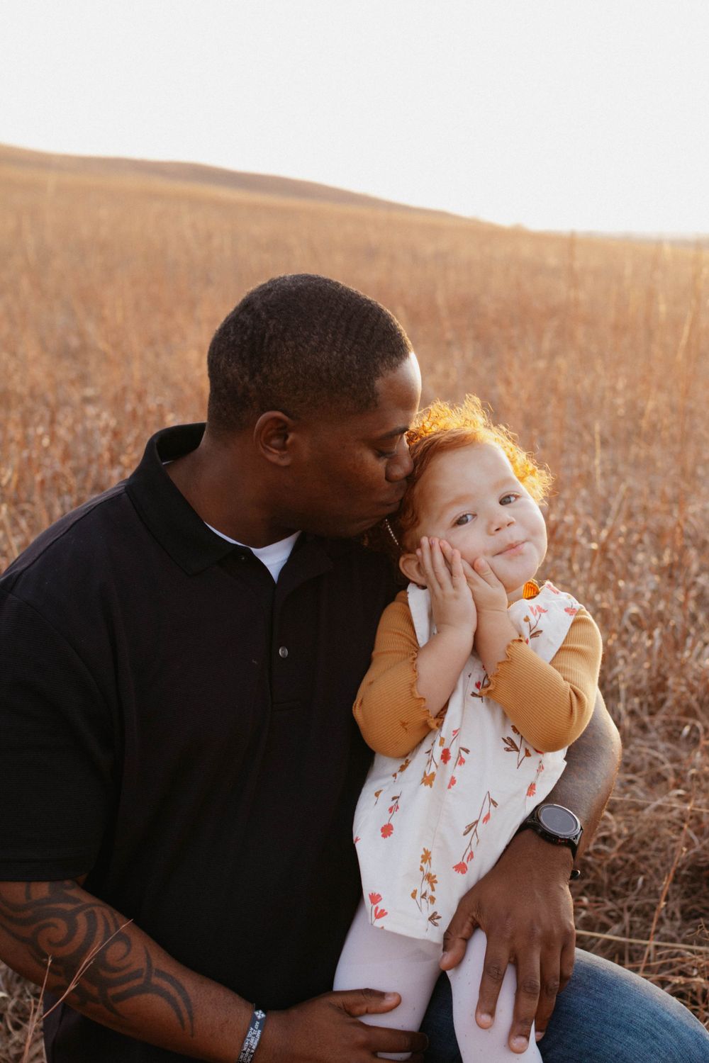 Sweet outdoor portrait in golden field shows tender moment between parent and child at sunset. Family lifestyle photoshoot