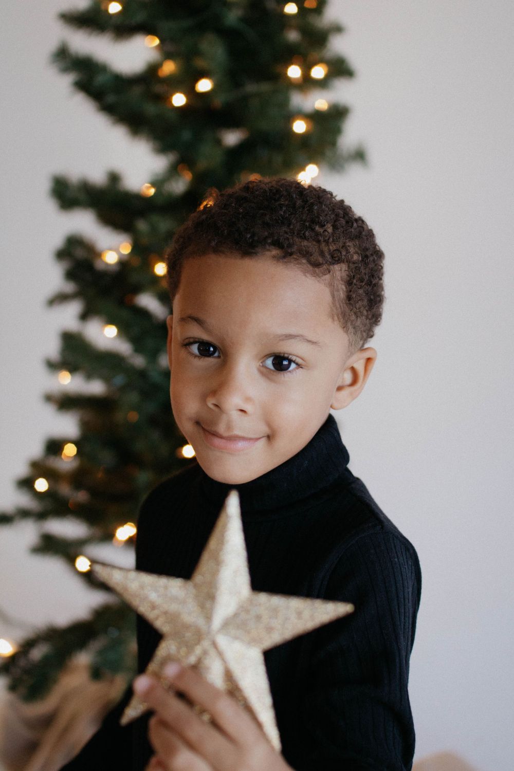 kid photoshoot of Christmas tree with twinkling lights. holidays photoshoot family