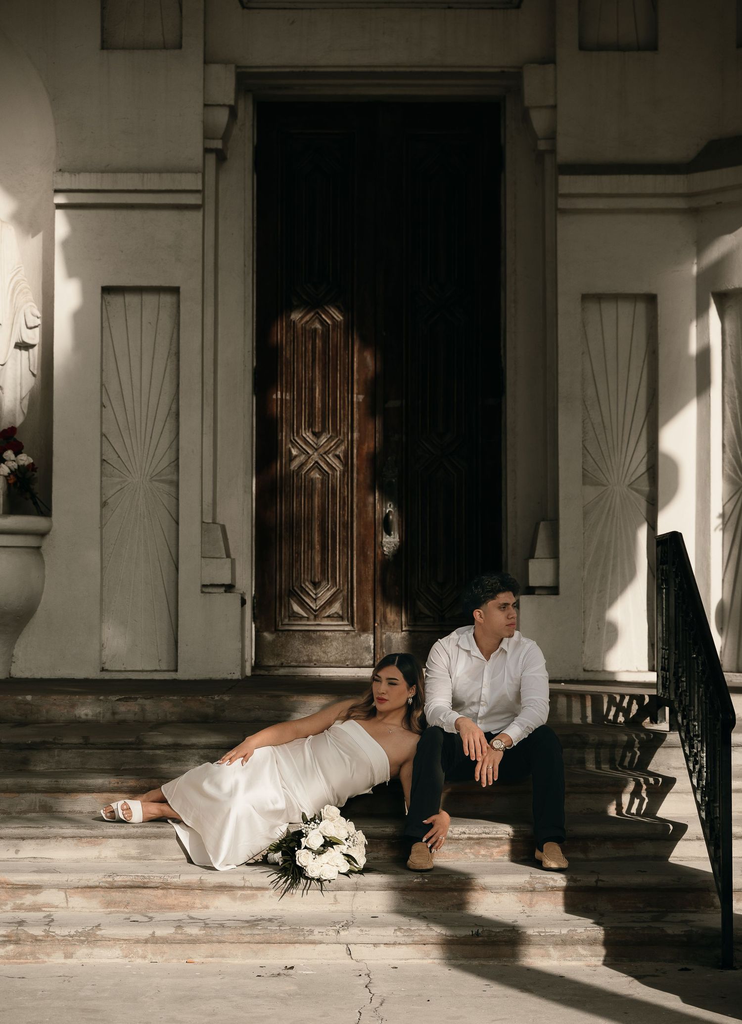 Wedding couple embraces in front of gothic church architecture.