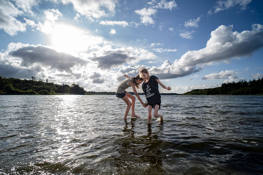Billede af to piger der leger ud i Stubbergård sø en sommerdag