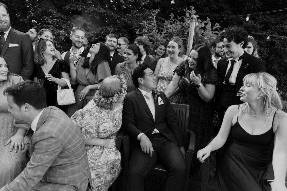 large well dressed group at wedding laughing and joking