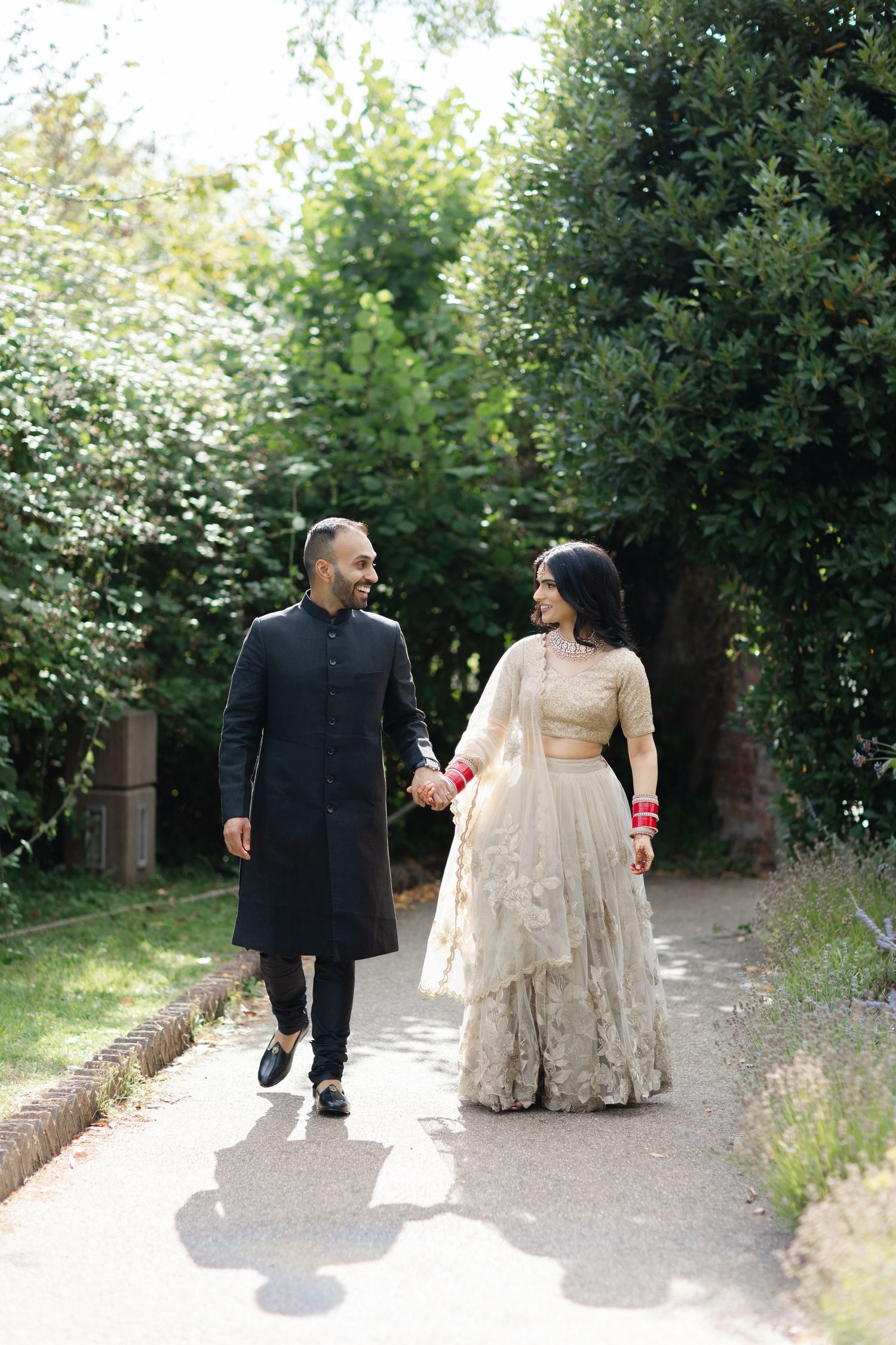 Indian bride and groom walking at the Great Barn in Harrow