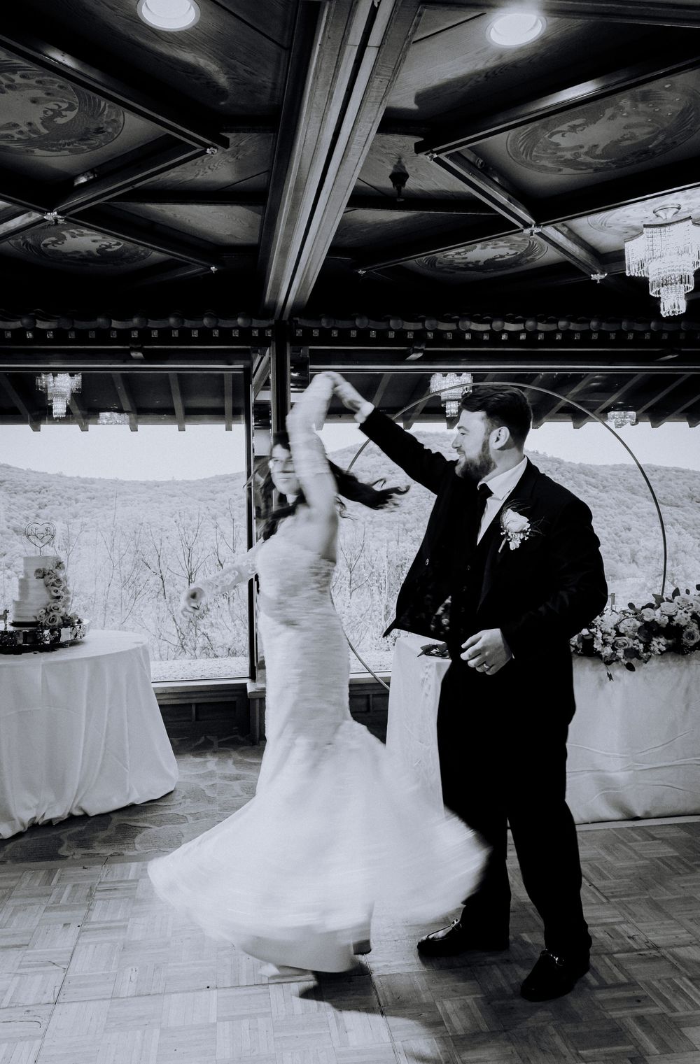 A bride and groom dance together on a classic wooden dance floor during their wedding reception.