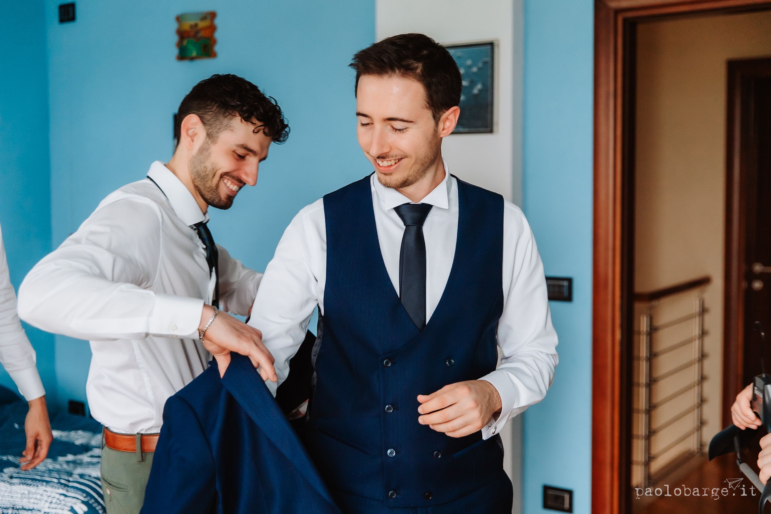A person getting ready for a formal event checks their outfit in a blue-walled room.