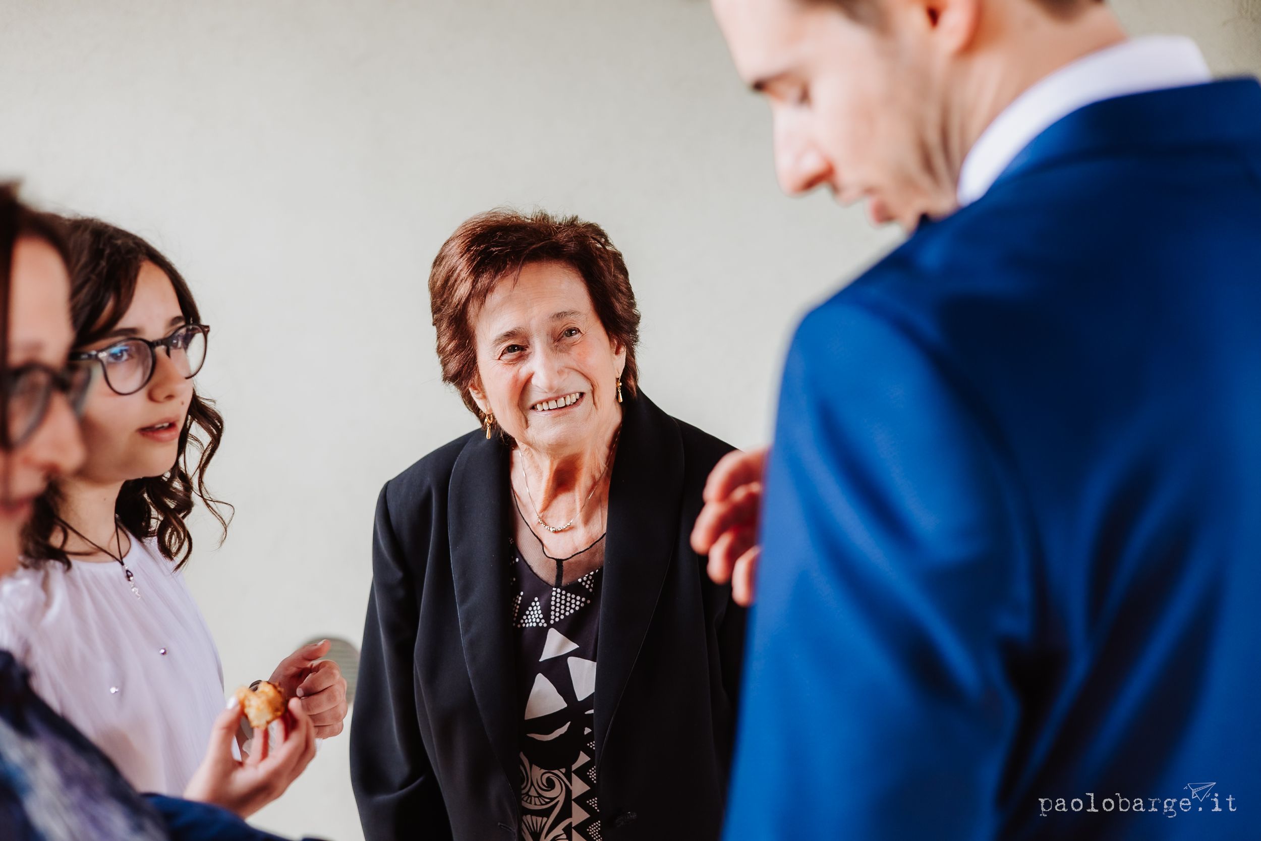 A candid moment at a social gathering shows attendees engaged in lively conversation.